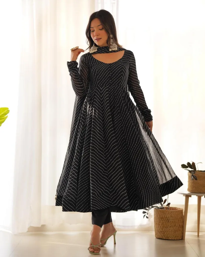 Woman wearing a black leheriya printed Anarkali kurta with matching pants and dupatta, front view ethnic festive wear suit set.