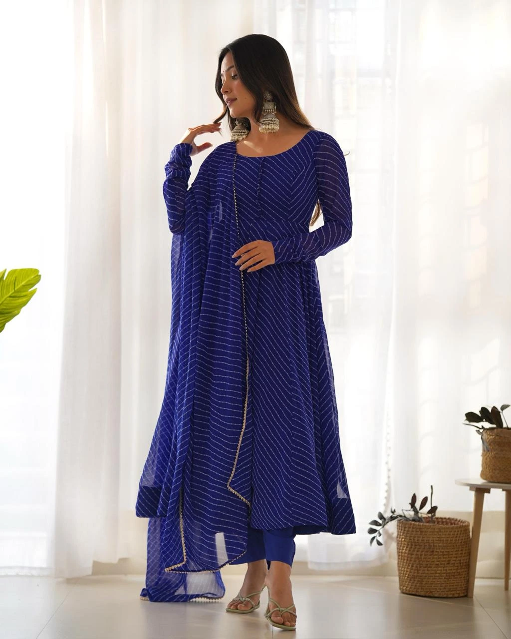 blue-anarkali-suit-set-front-view Woman wearing a blue leheriya printed Anarkali kurta with matching pants and dupatta, front view ethnic festive wear suit set.